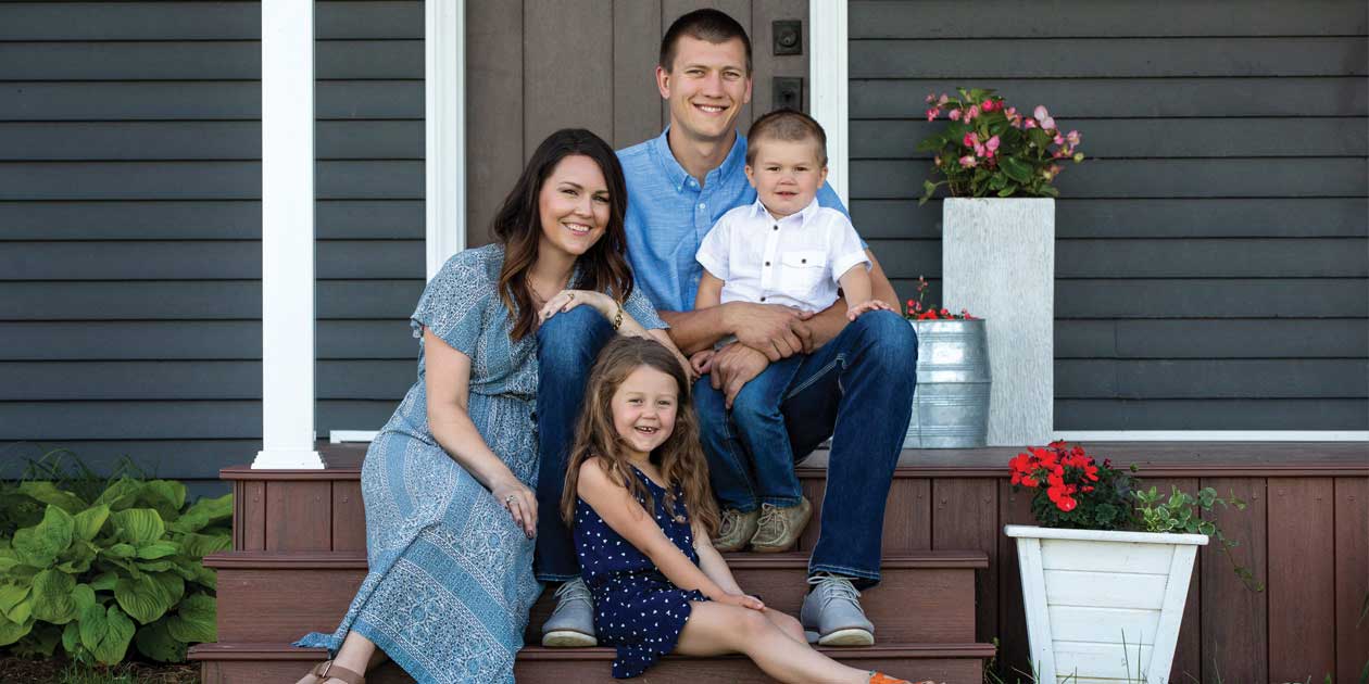 The four members of the Von Ahsen family pose on the front steps of their home