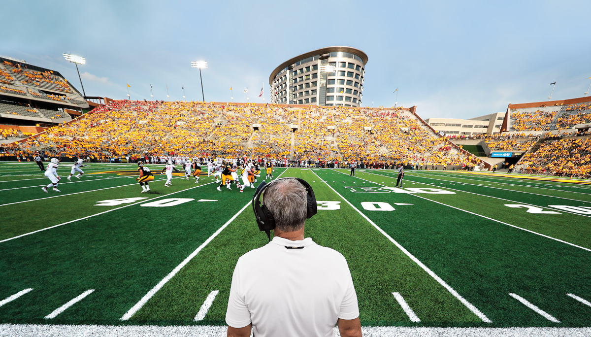 the Iowa Hawkeyes play a football game at Kinnick Stadium; UI Stead Family Children's Hospital is seen overlooking the stadium in the background