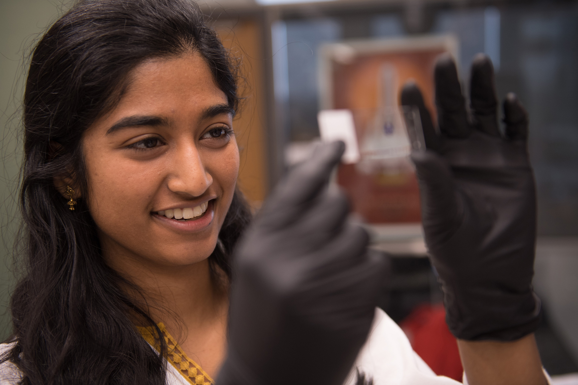 Velarchana Santhana examining a slide in her lab
