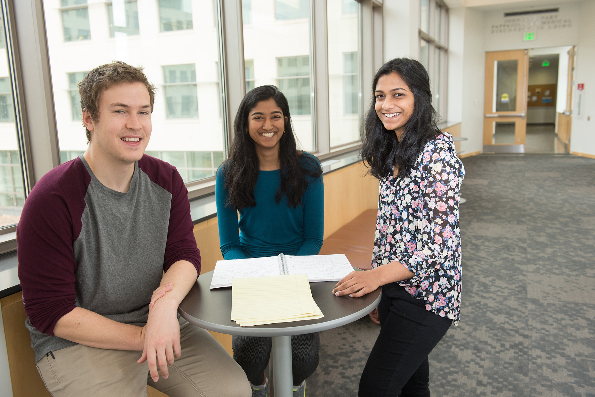 three undergraduates sitting in research facility