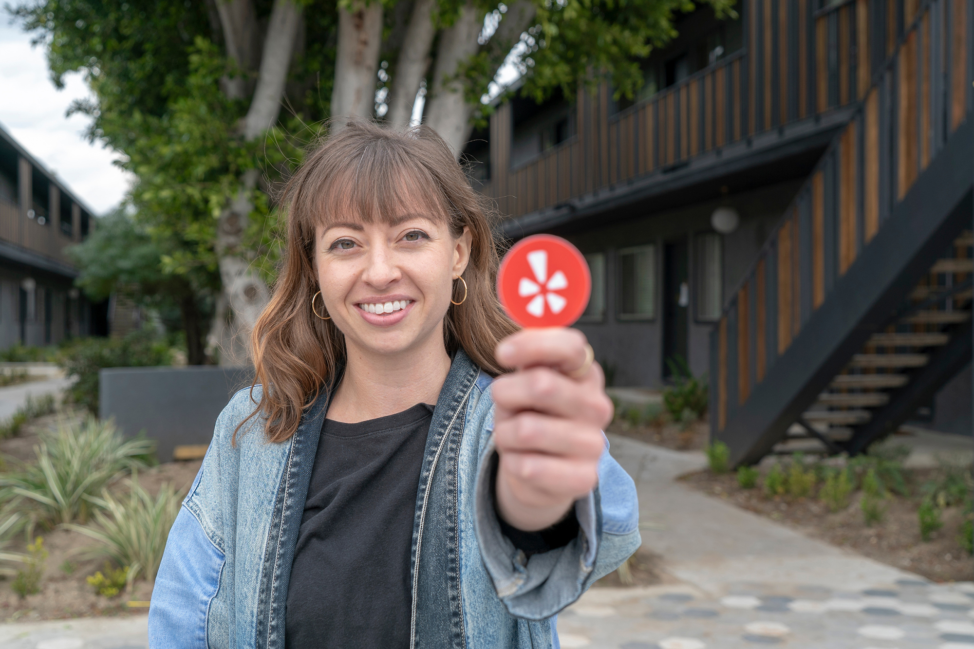 university of iowa alumna megan ranegar holds up a yelp icon