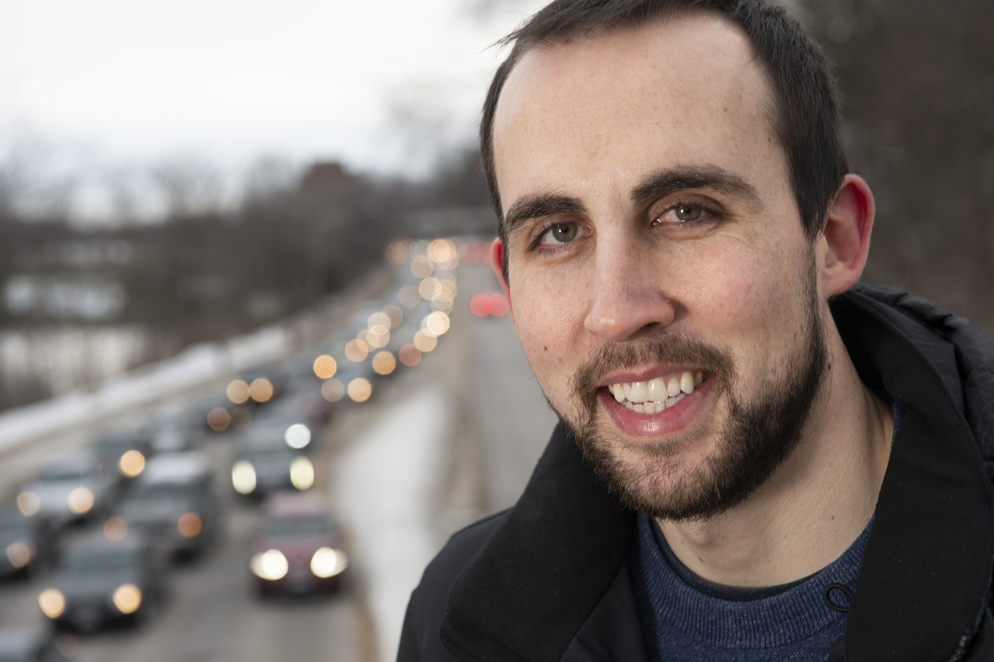 University of Iowa doctoral student Michael Redmond posing near a busy street