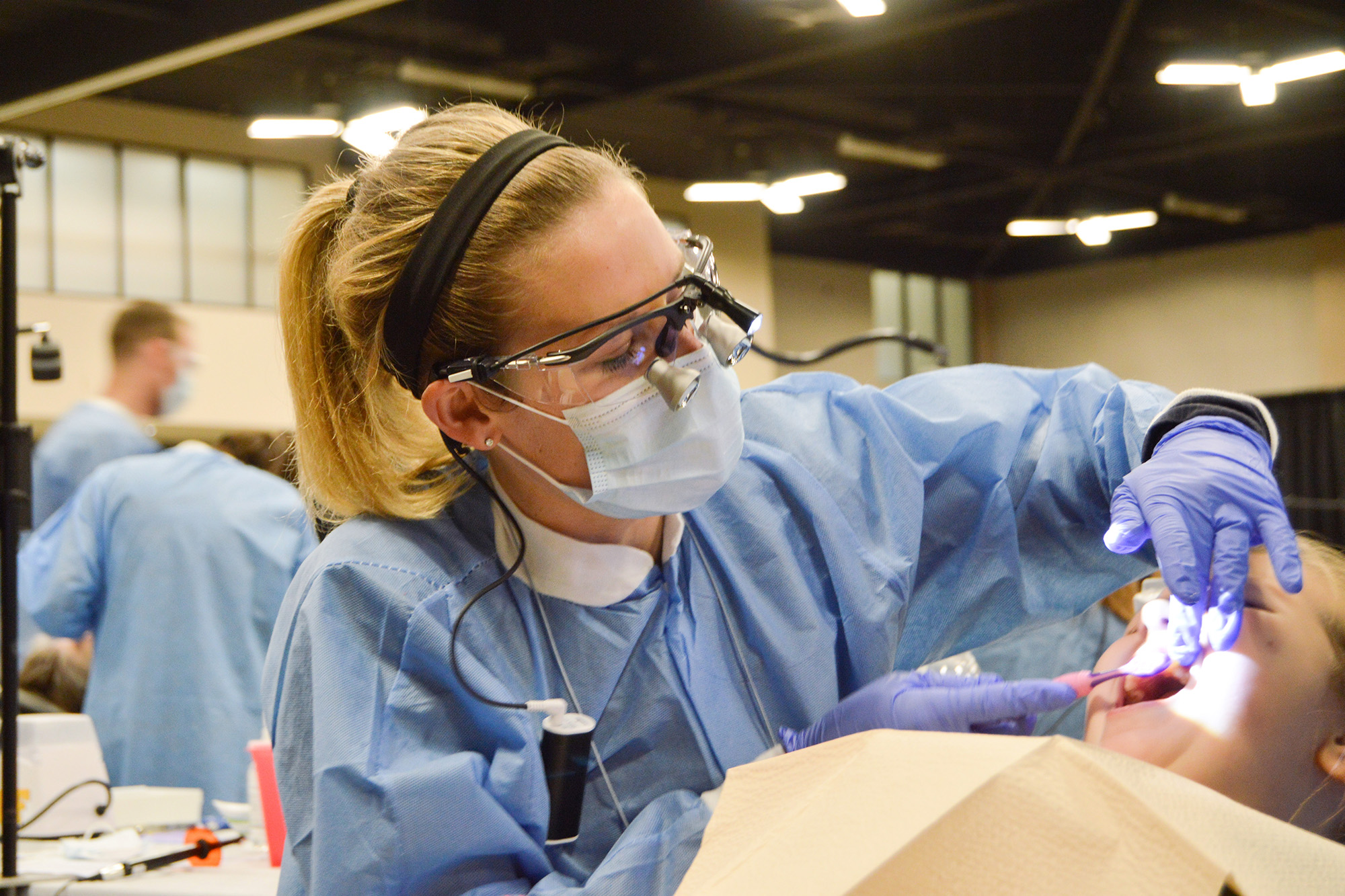 a woman performs dental work for a child