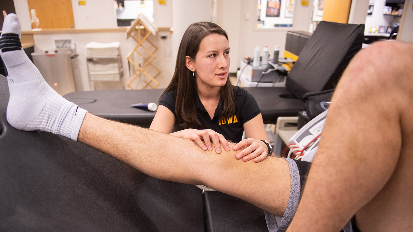 University of Iowa athletic training student Zoe Hicks works with a basketball player