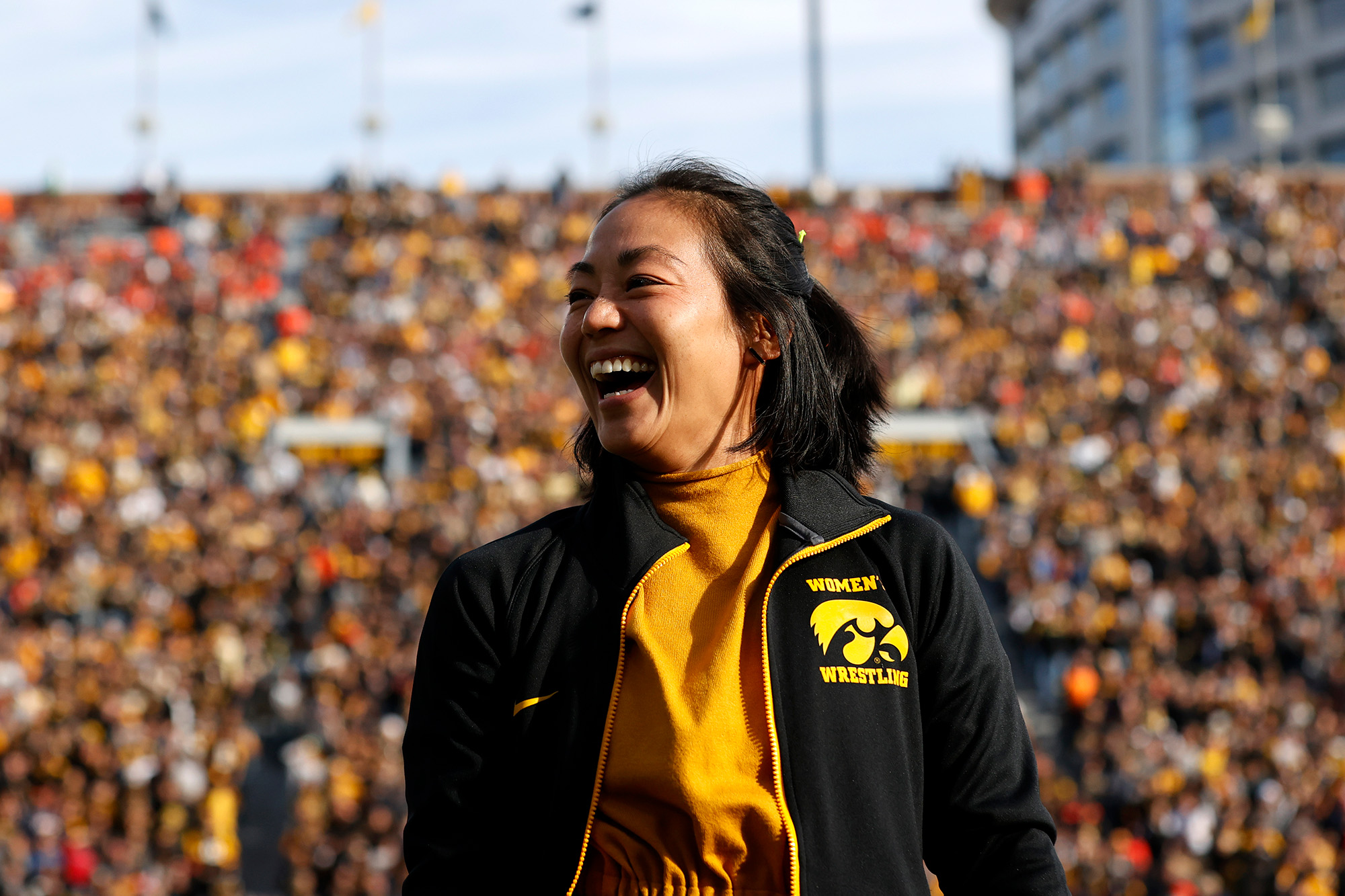 university of iowa women's wrestling coach Clarissa Chun smiles while being introduced at a football game
