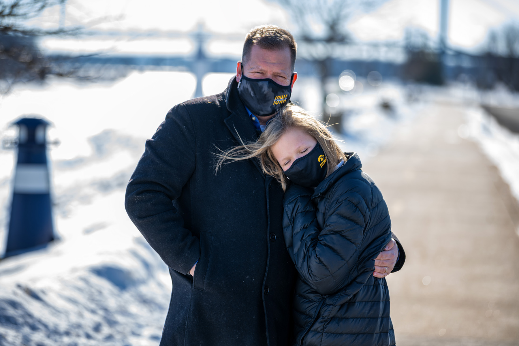 Daniel Ivory and his daughter Lydia wearing face masks with Tiger hawk logos, standing outdoors on a sunny winter day