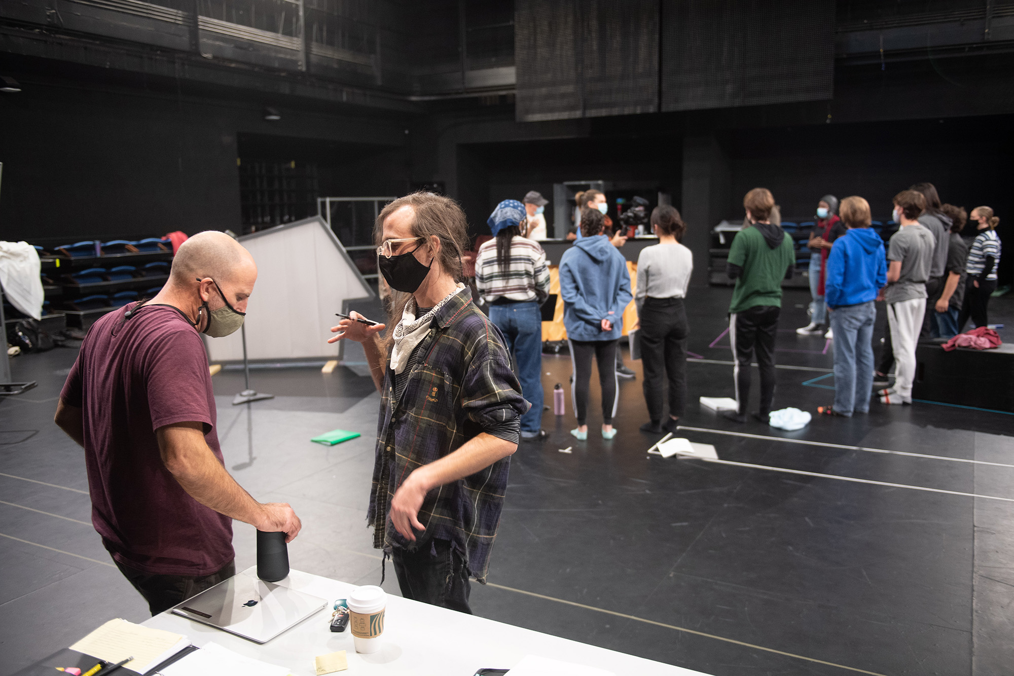 Iowa Playwrights Workshop graduate Dakota Parobek (foreground, right) speaks with director Paul Kalina on the set of Smile Medicine, written by Parobek and part of the University of Iowa's Mainstage 2021-22 theater season