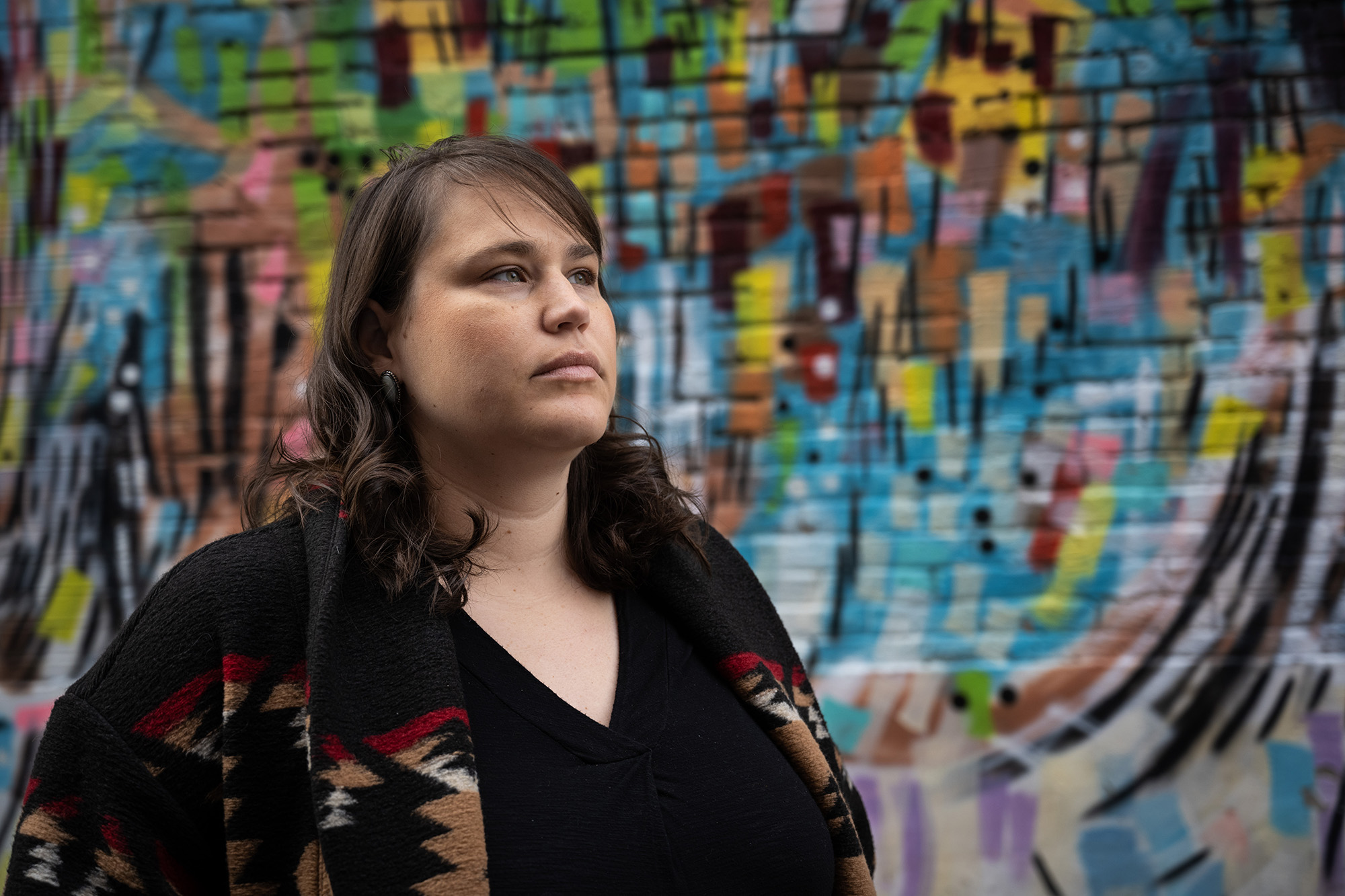 University of Iowa faculty member Carrie Schuettpelz standing in front of a colorful wall