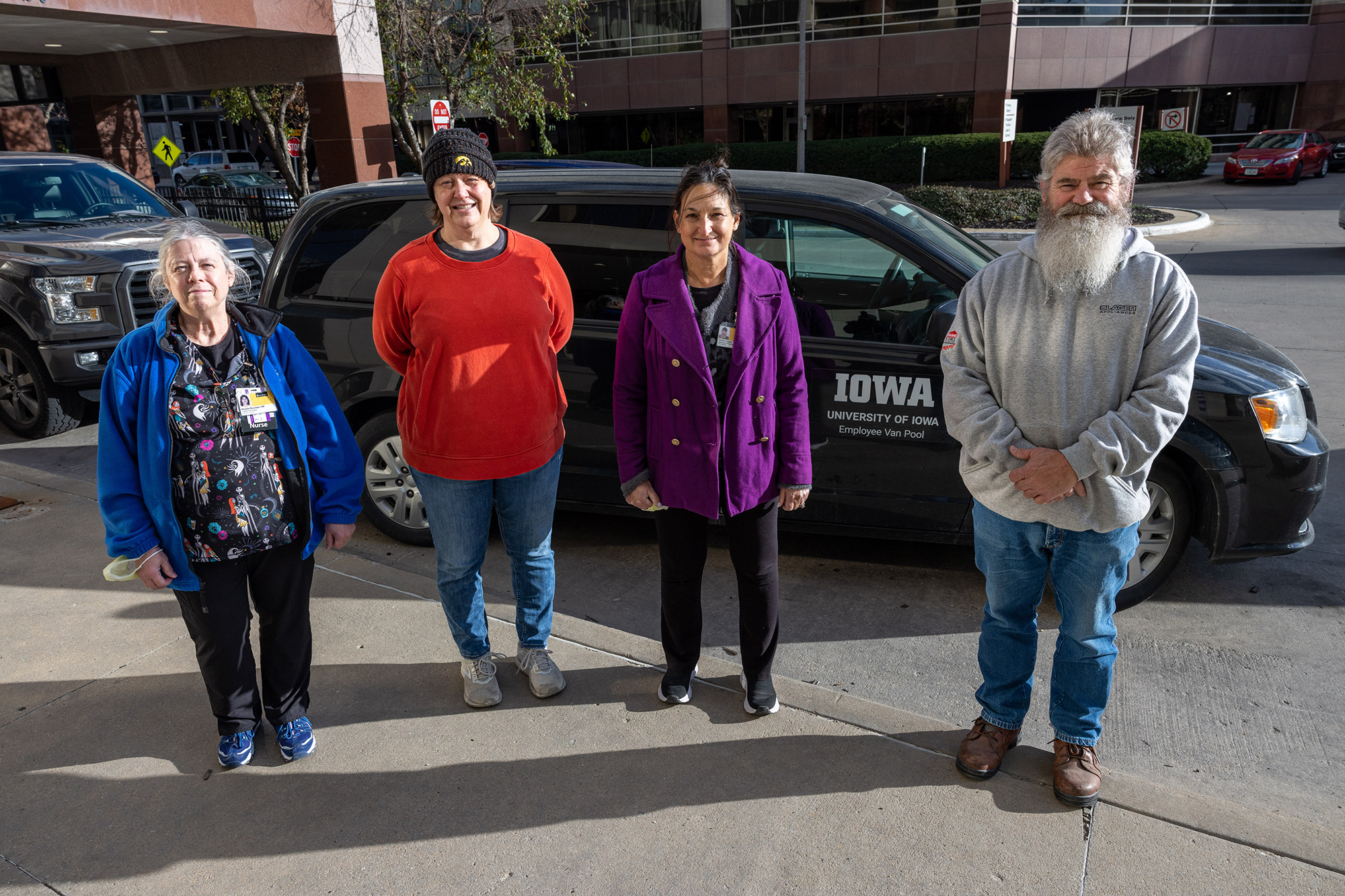 four University of Iowa Health Care employees standing in front of a van
