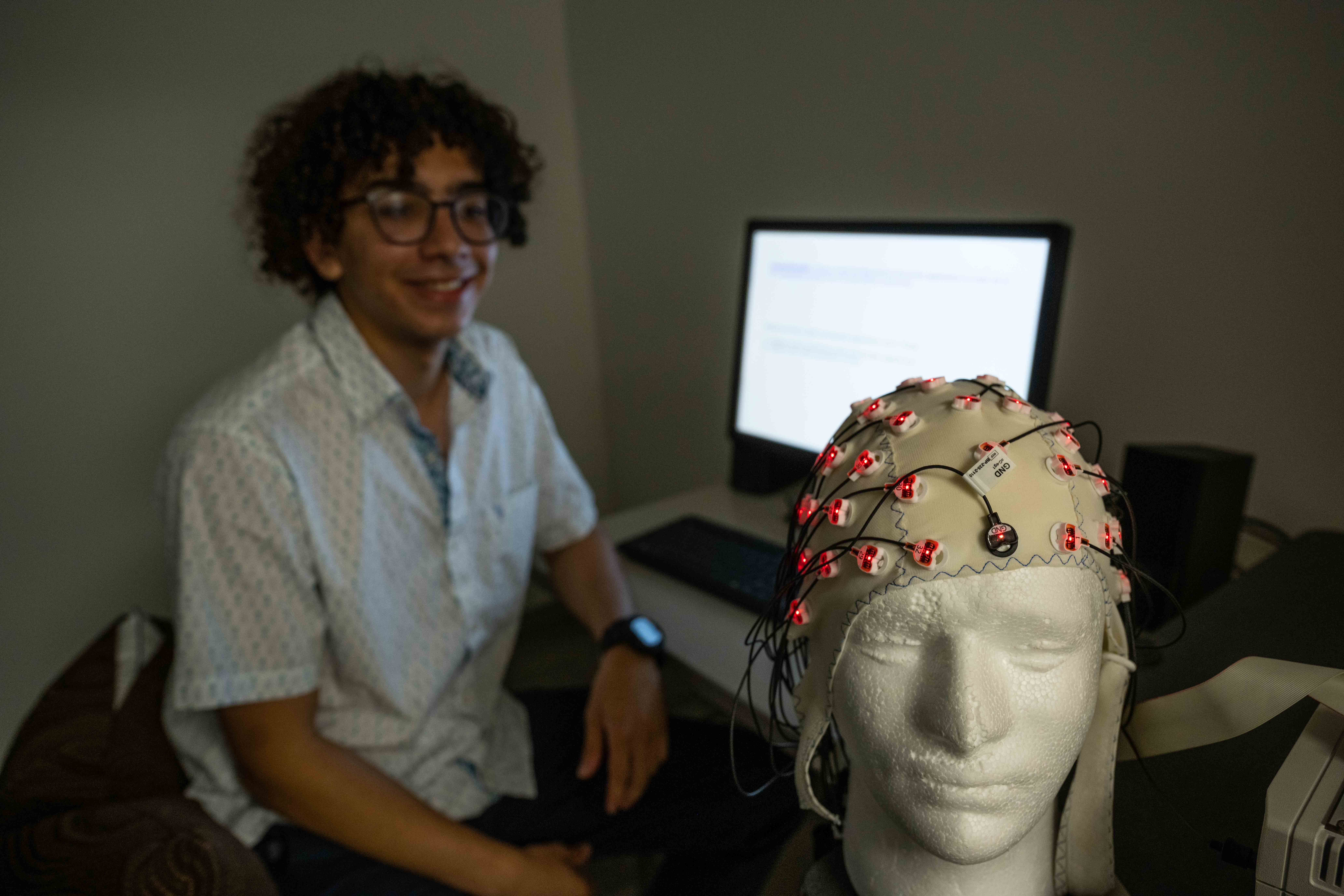 Student sitting at desk with brain model