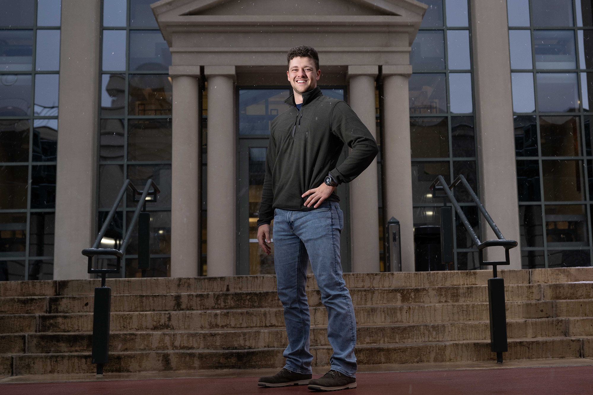 University of Iowa graduating student Noah Tarantello stands in front of a building on campus