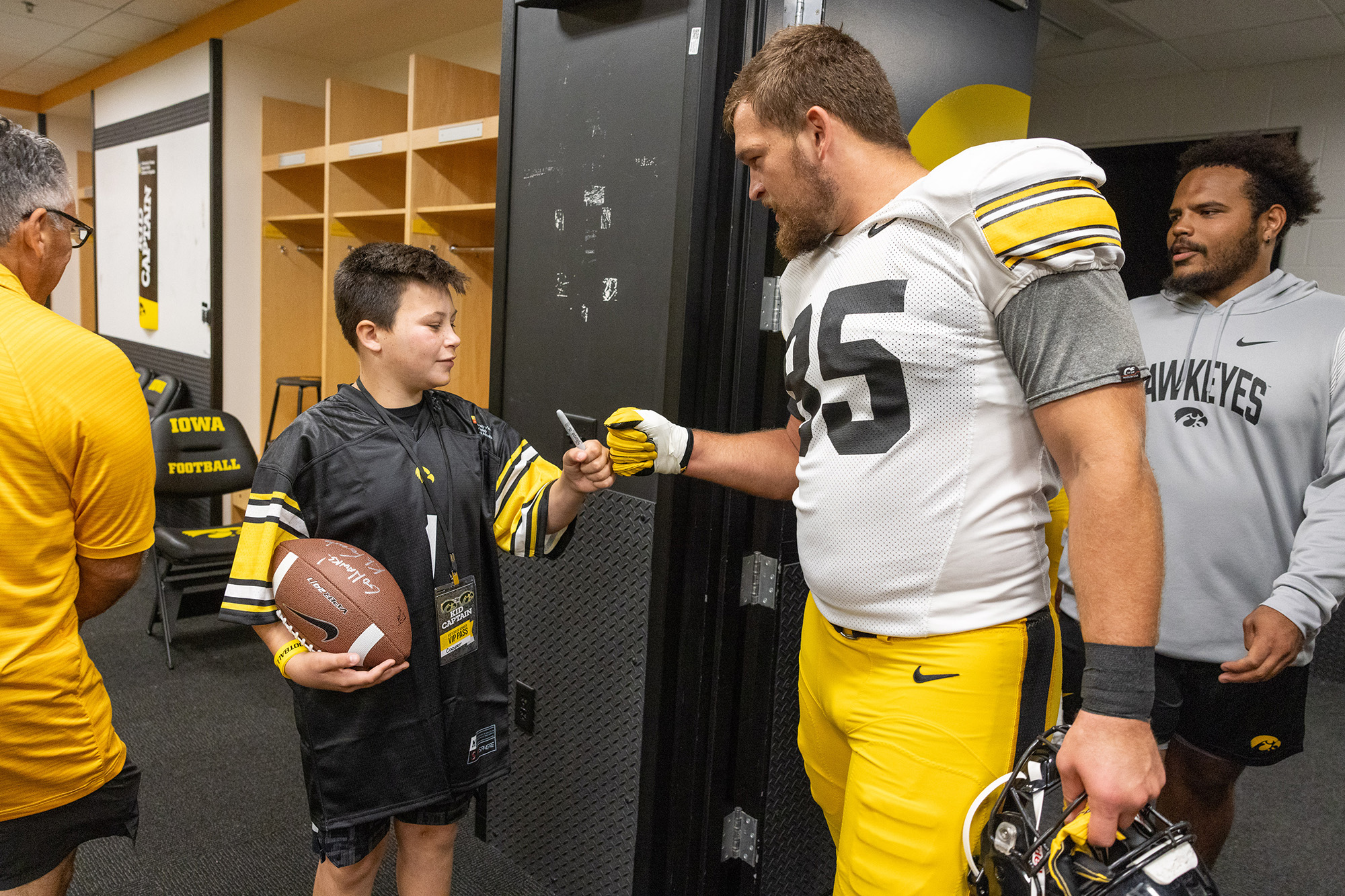 Kid Captain Cooper Estenson meeting an Iowa player at Kids Day at Kinnick