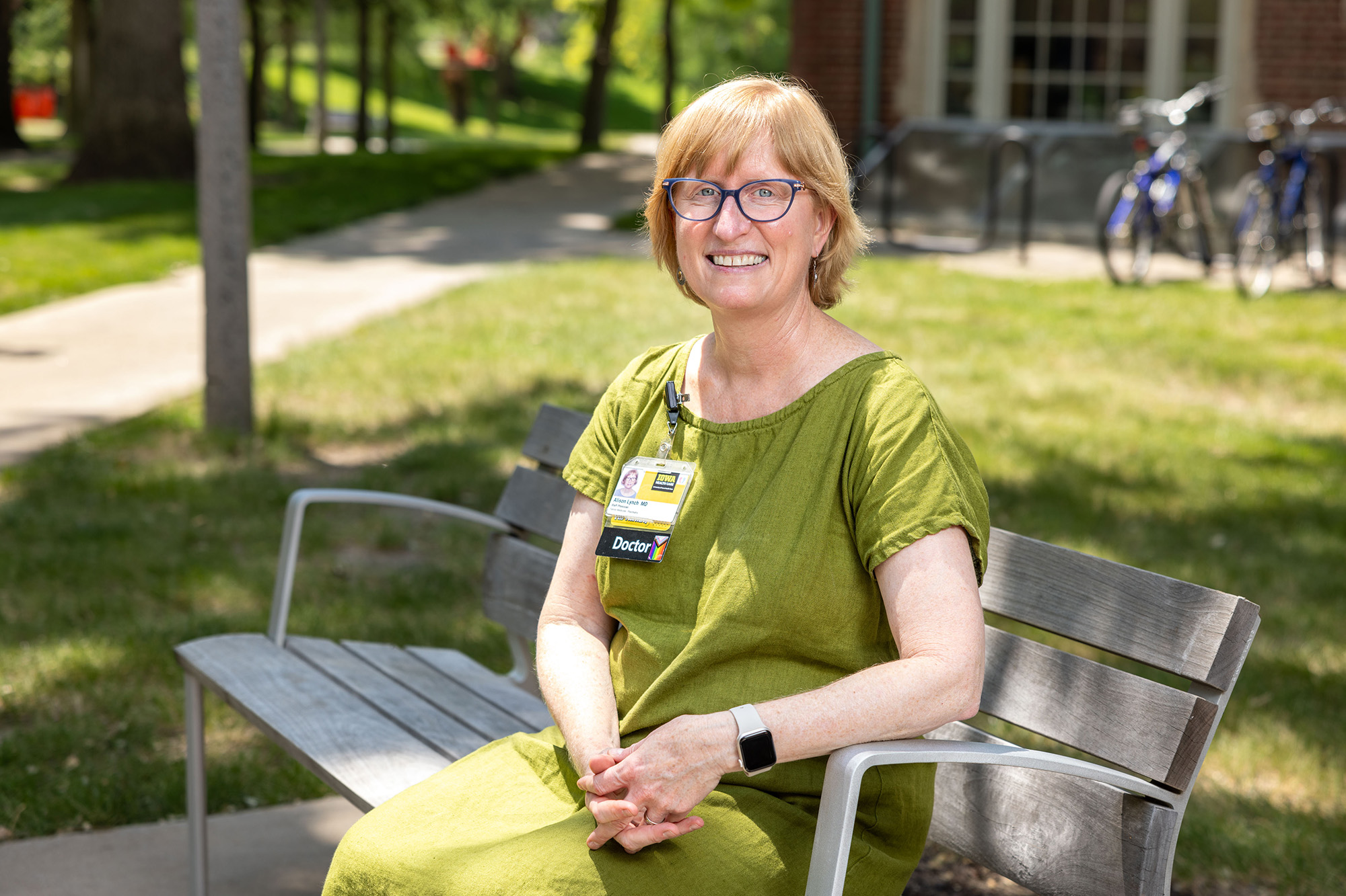 University of Iowa faculty member Alison Lynch sitting on a bench outdoors