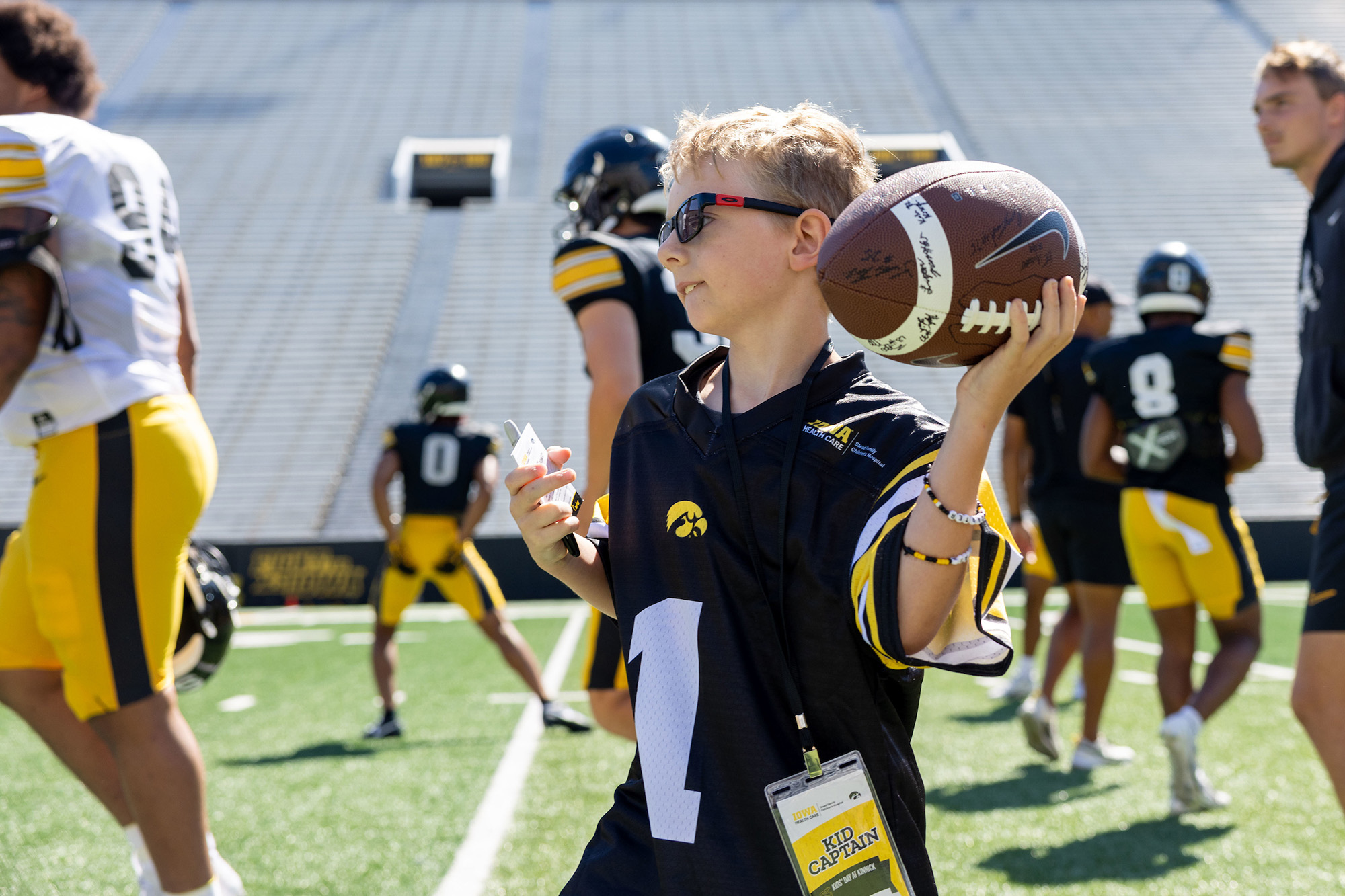 a young boy throwing a football at Kinnick Stadium