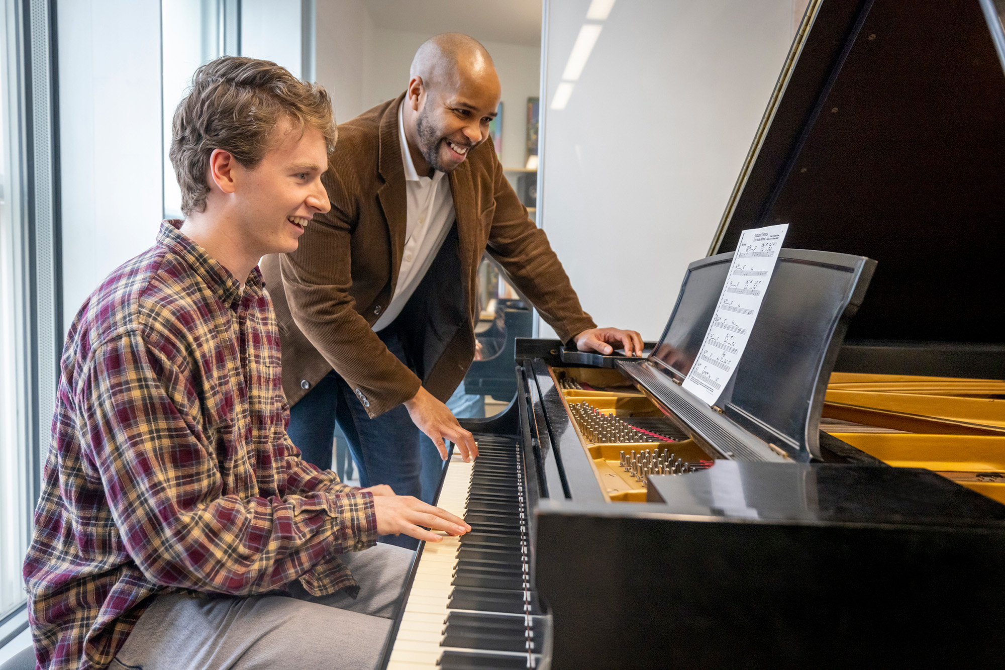 University of Iowa School of Music student Sean Harken plays the piano while faculty member William Menefield watches