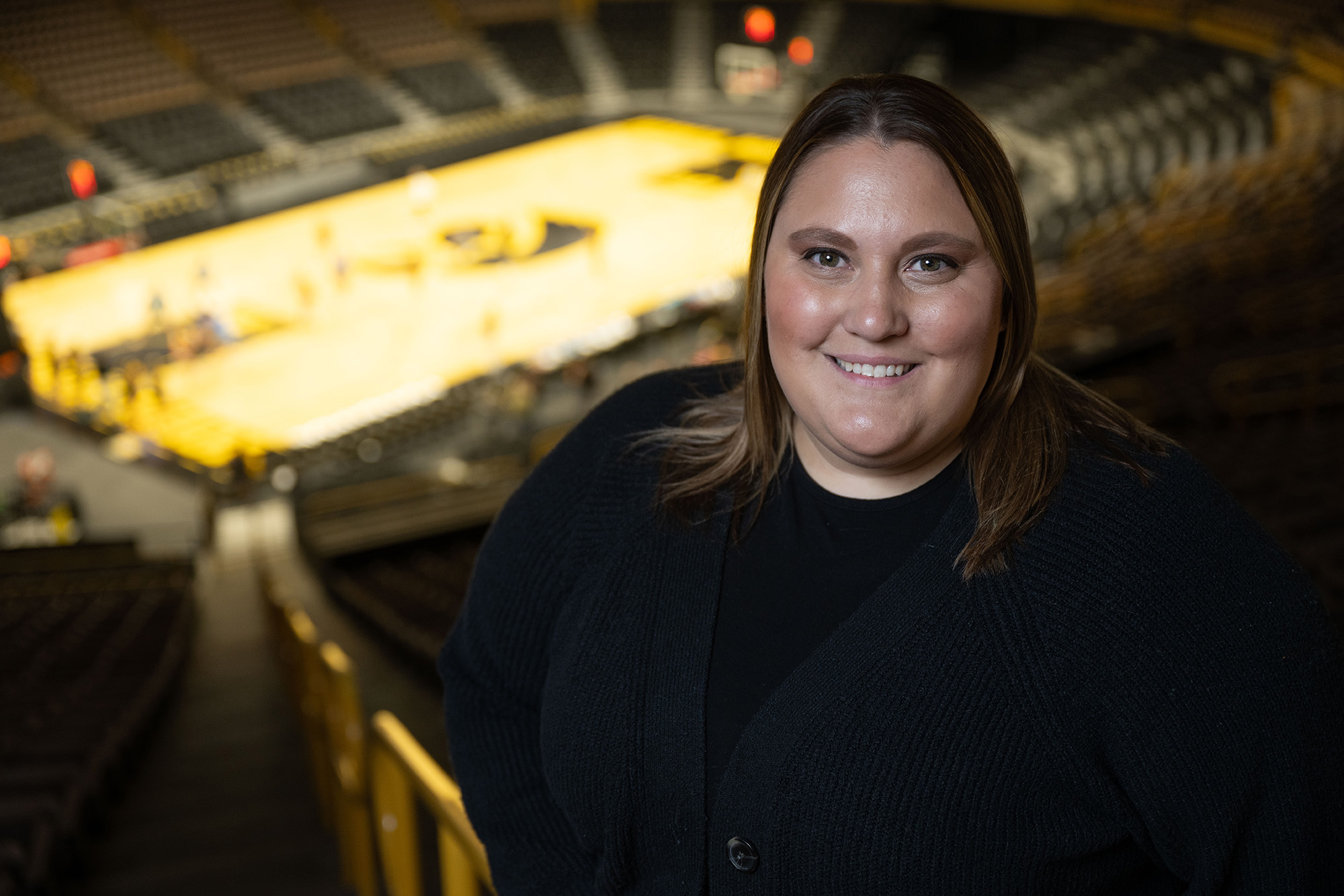 Brandee Britt inside Carver-Hawkeye Arena, with the basketball court in the background