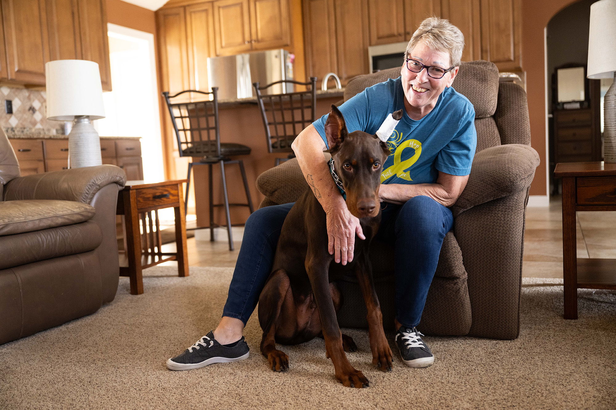 a woman sits in her living room with her dog