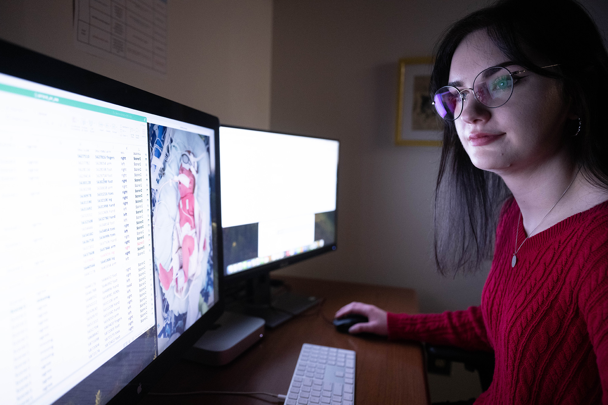 A woman sitting at a computer going over files