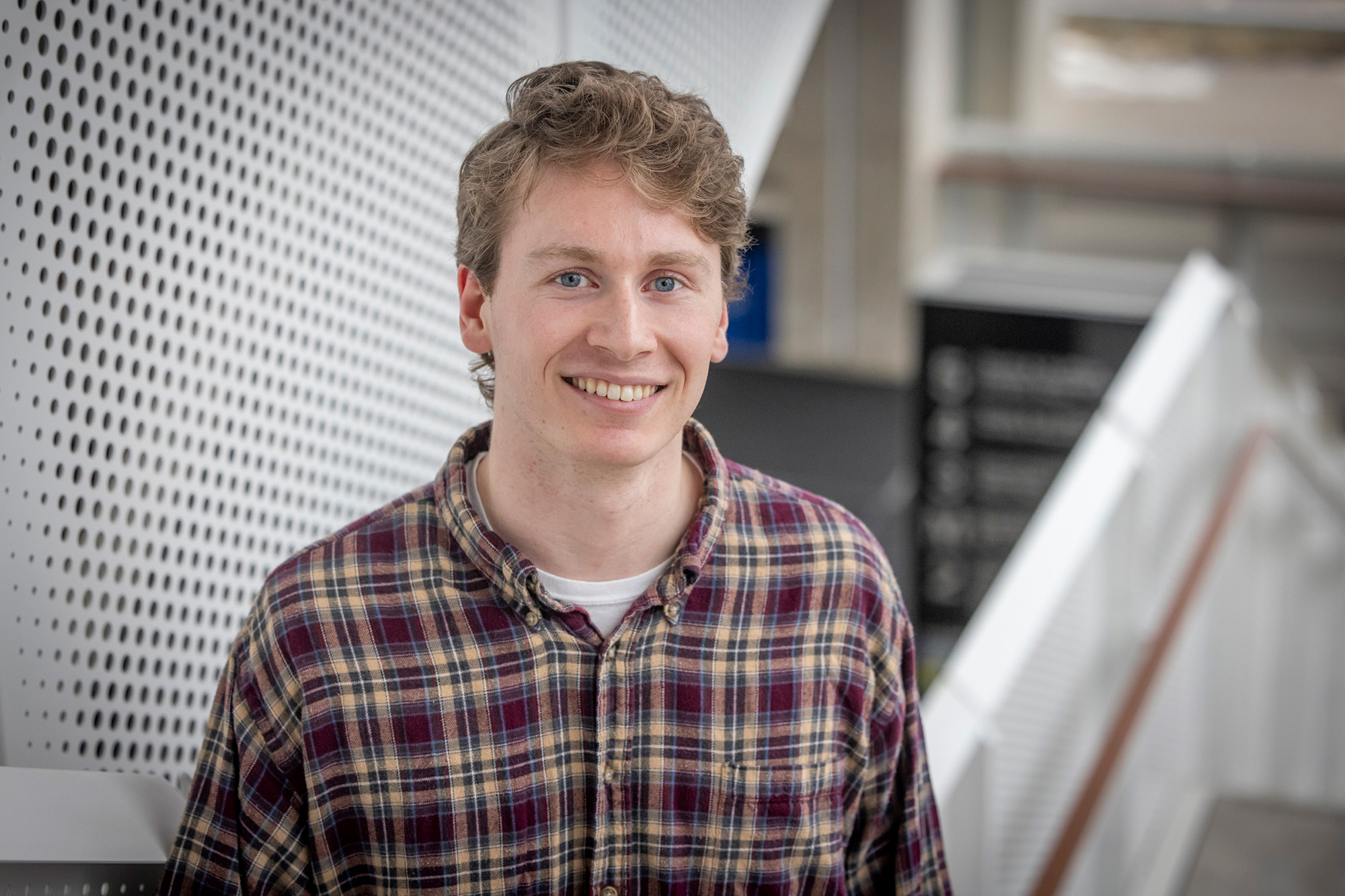 A man standing in a stairway smiling