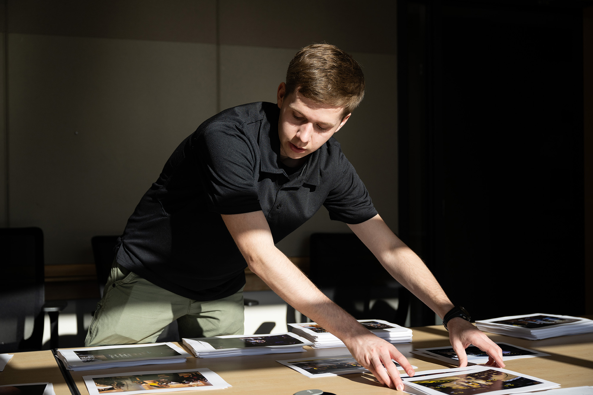 a photographer organizes stacks of photos on a table