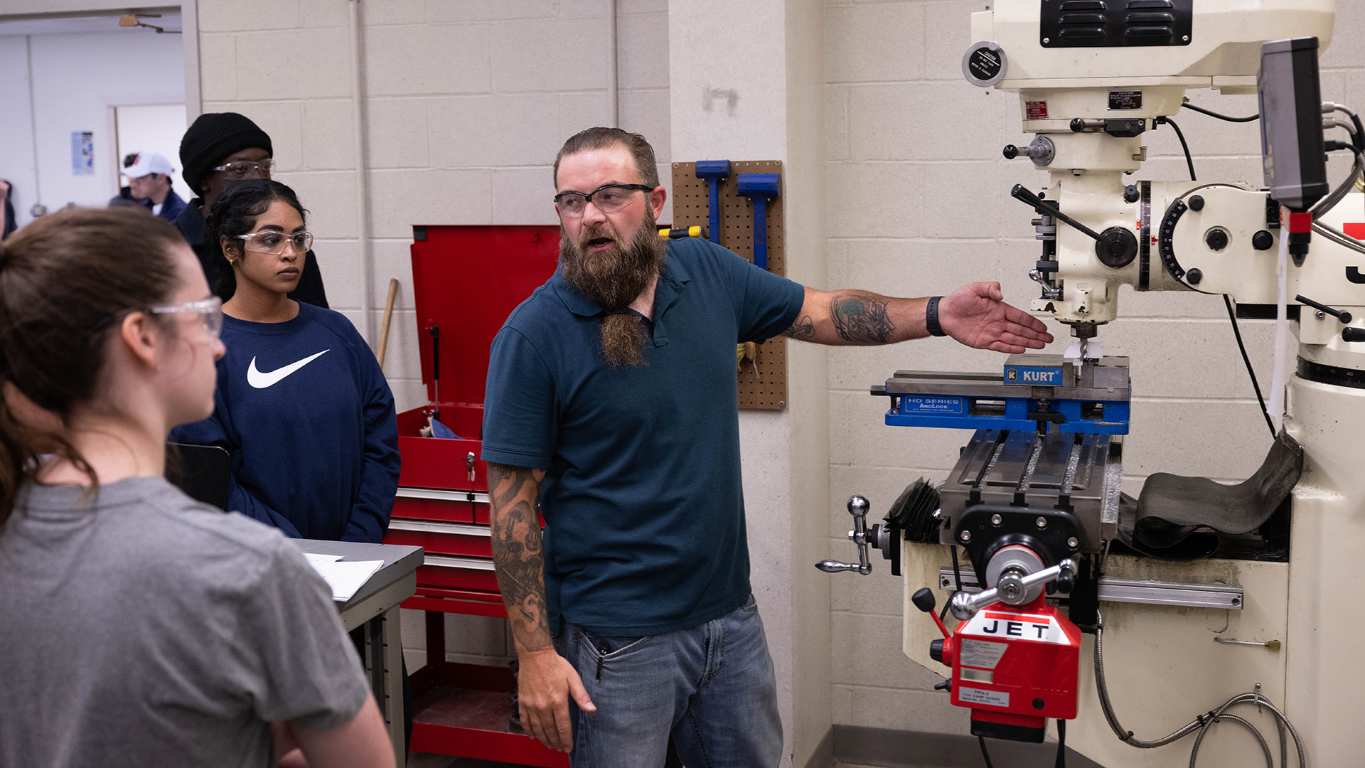 a graduate student instructing engineering students in a lab