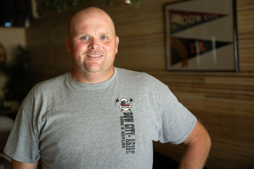 A man smiling wearing a fire and rescue shirt