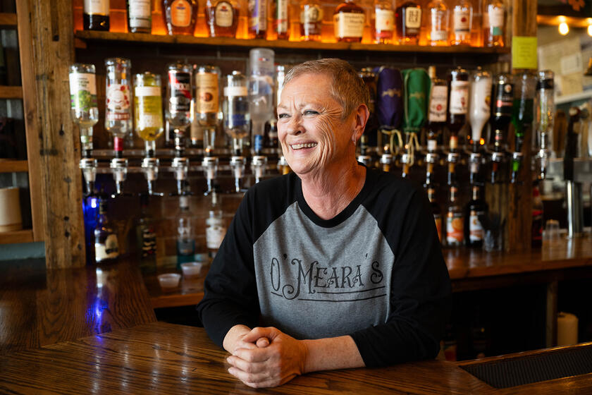 A woman leaning on a bar counter