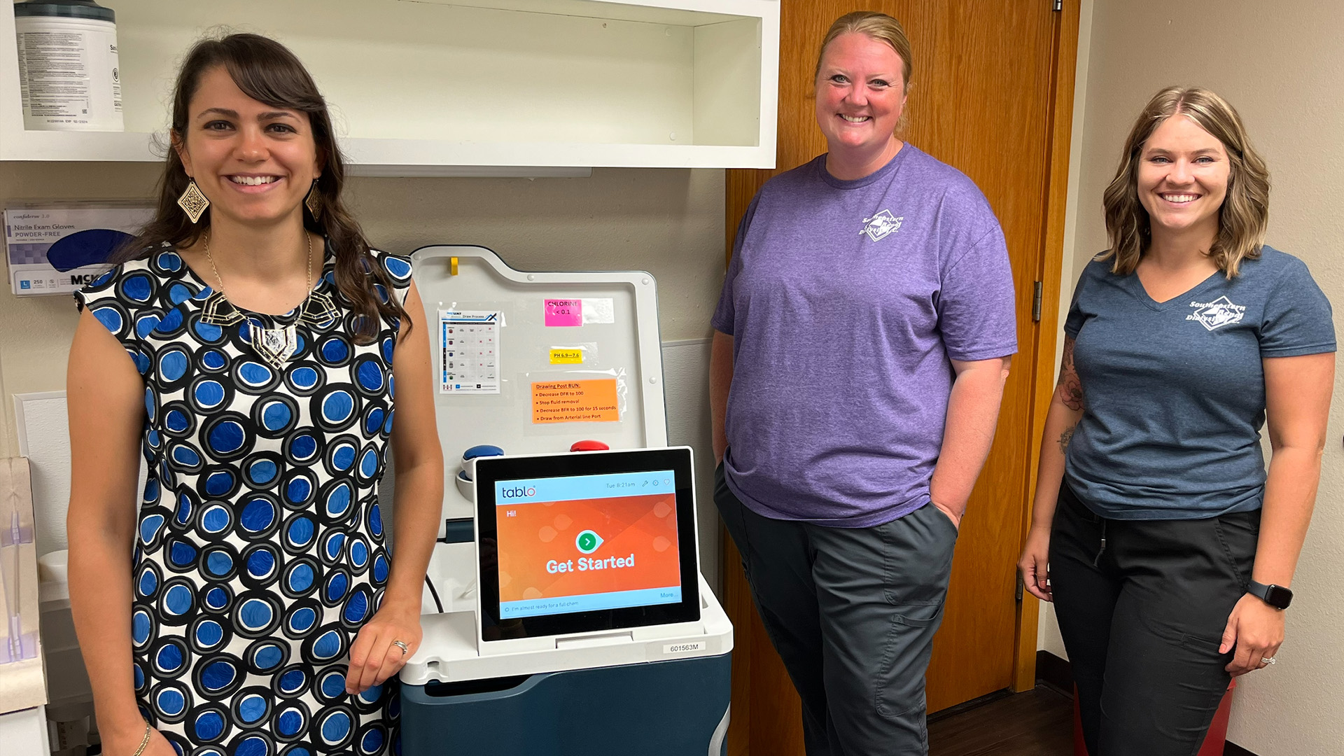 Three women standing around a new machine