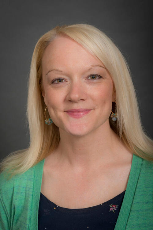 A woman smiling as she has her portrait taken