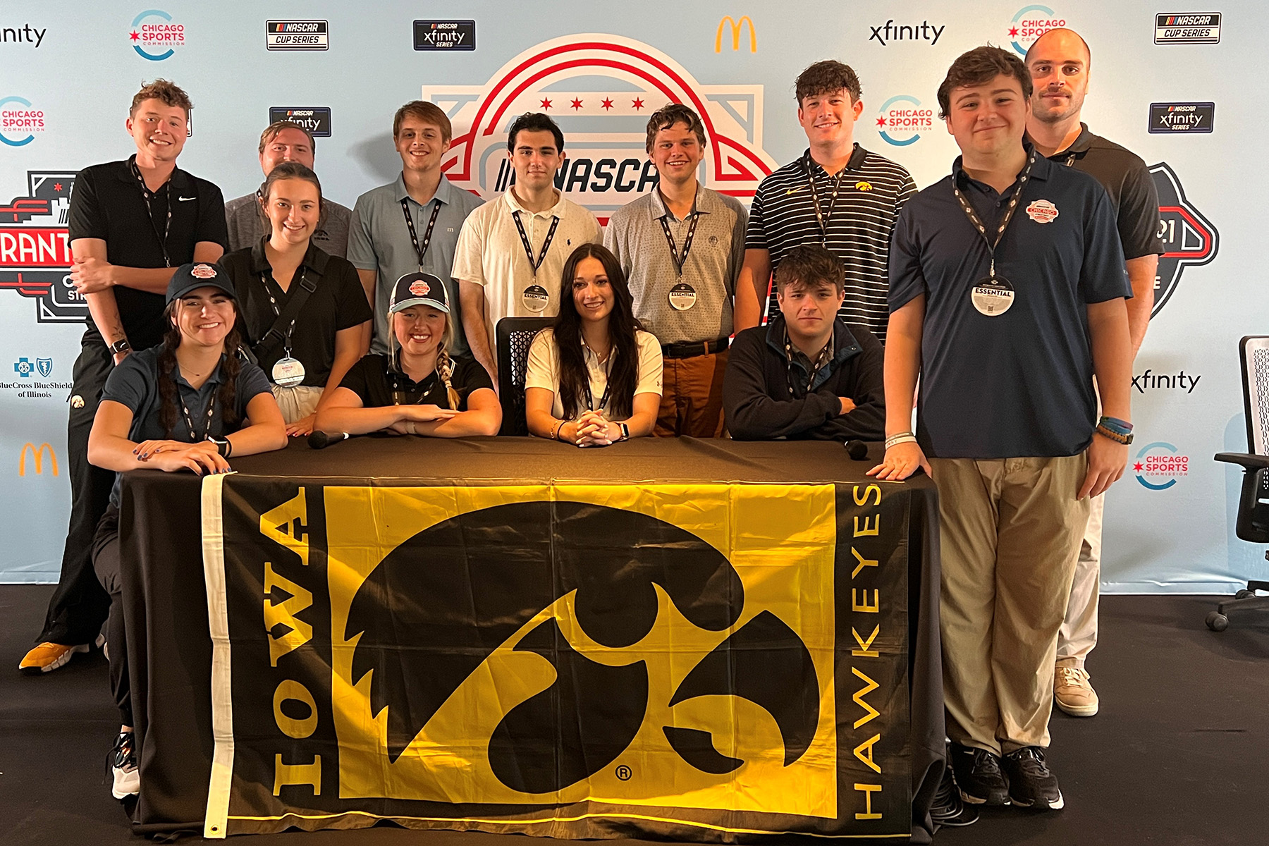 a group of people on a press conference stage with the tiger hawk flag