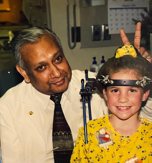 A doctor putting bunny ears behind a young patient
