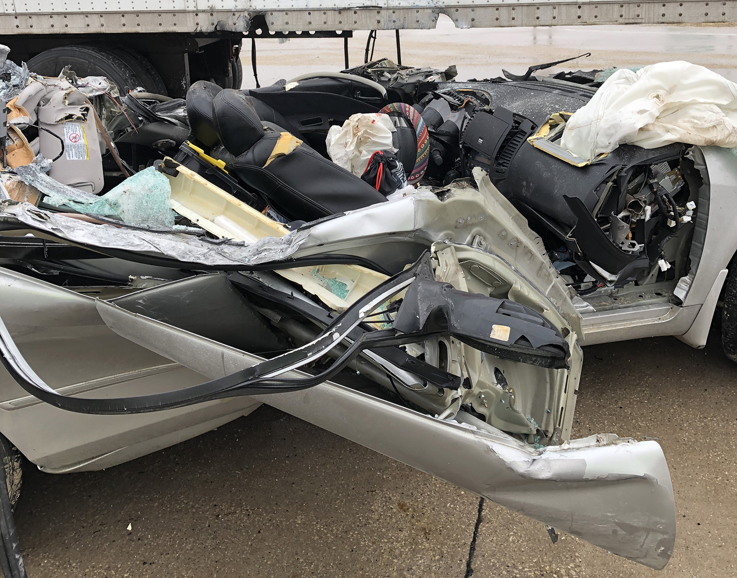 the car Maggie McQuillen was driving when the accident happened; the top is sheared off and parts are strewn about