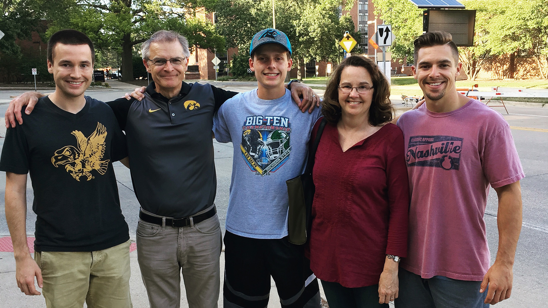 A family of five standing together outside