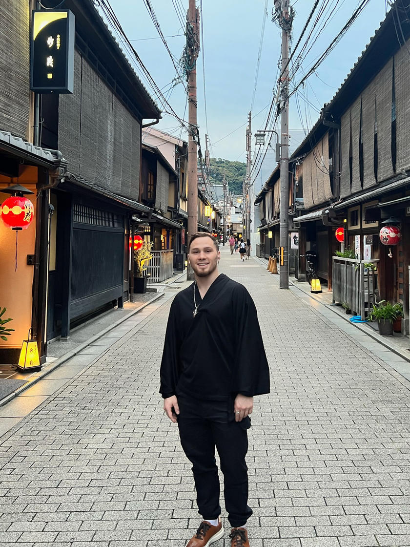 A man standing in the middle of the street smiling