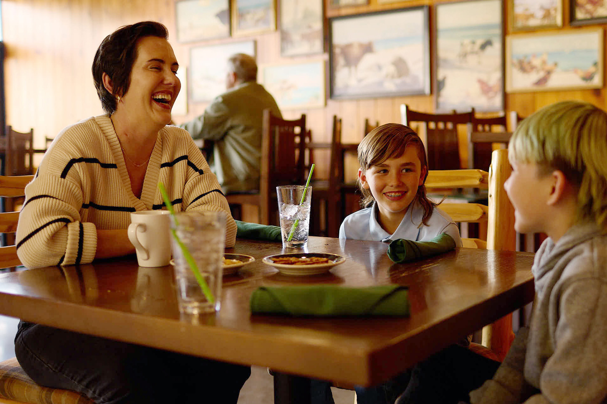 A mother sitting down for a meal with her two kids