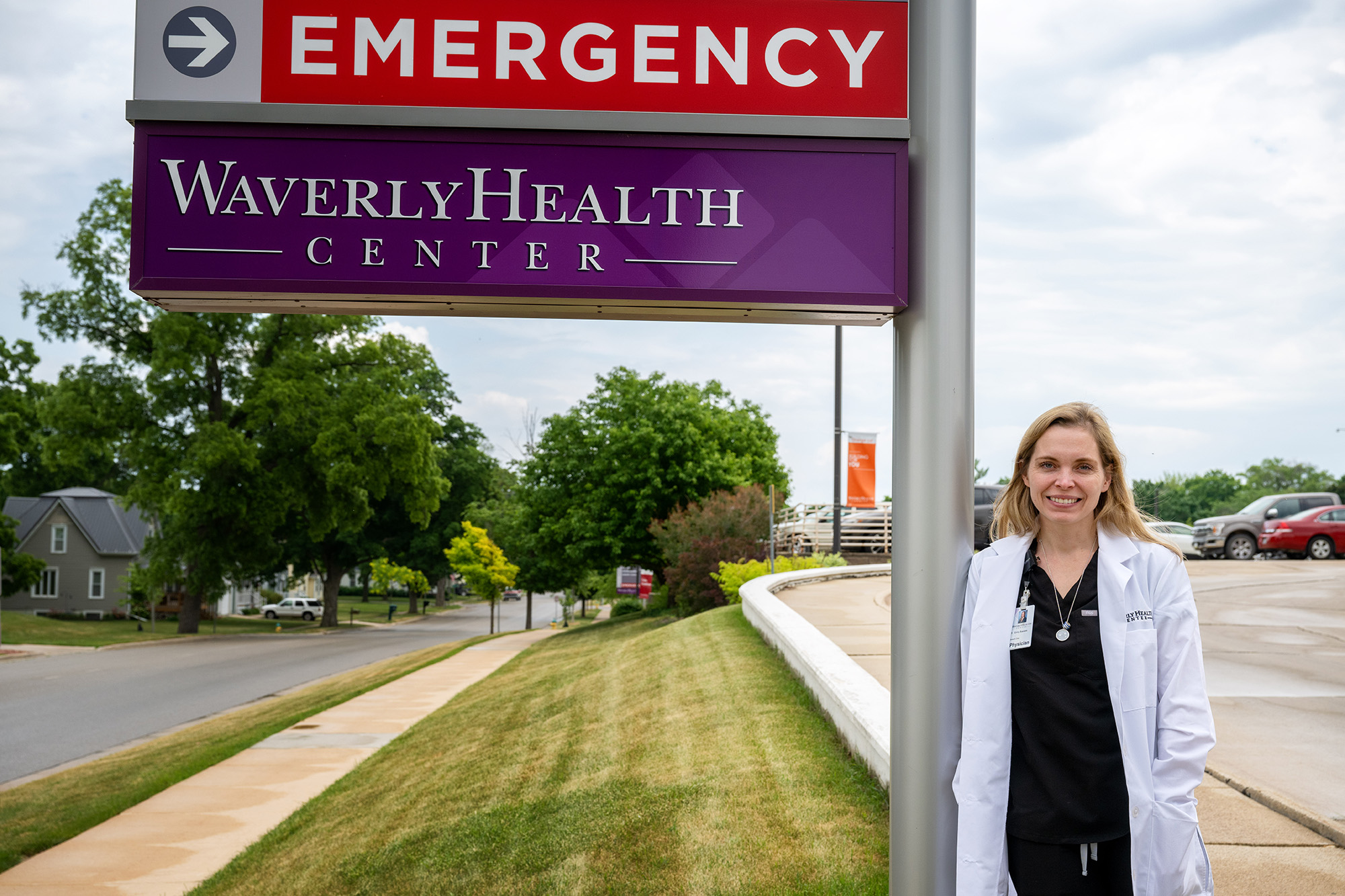 A doctor standing next to an emergency room sign