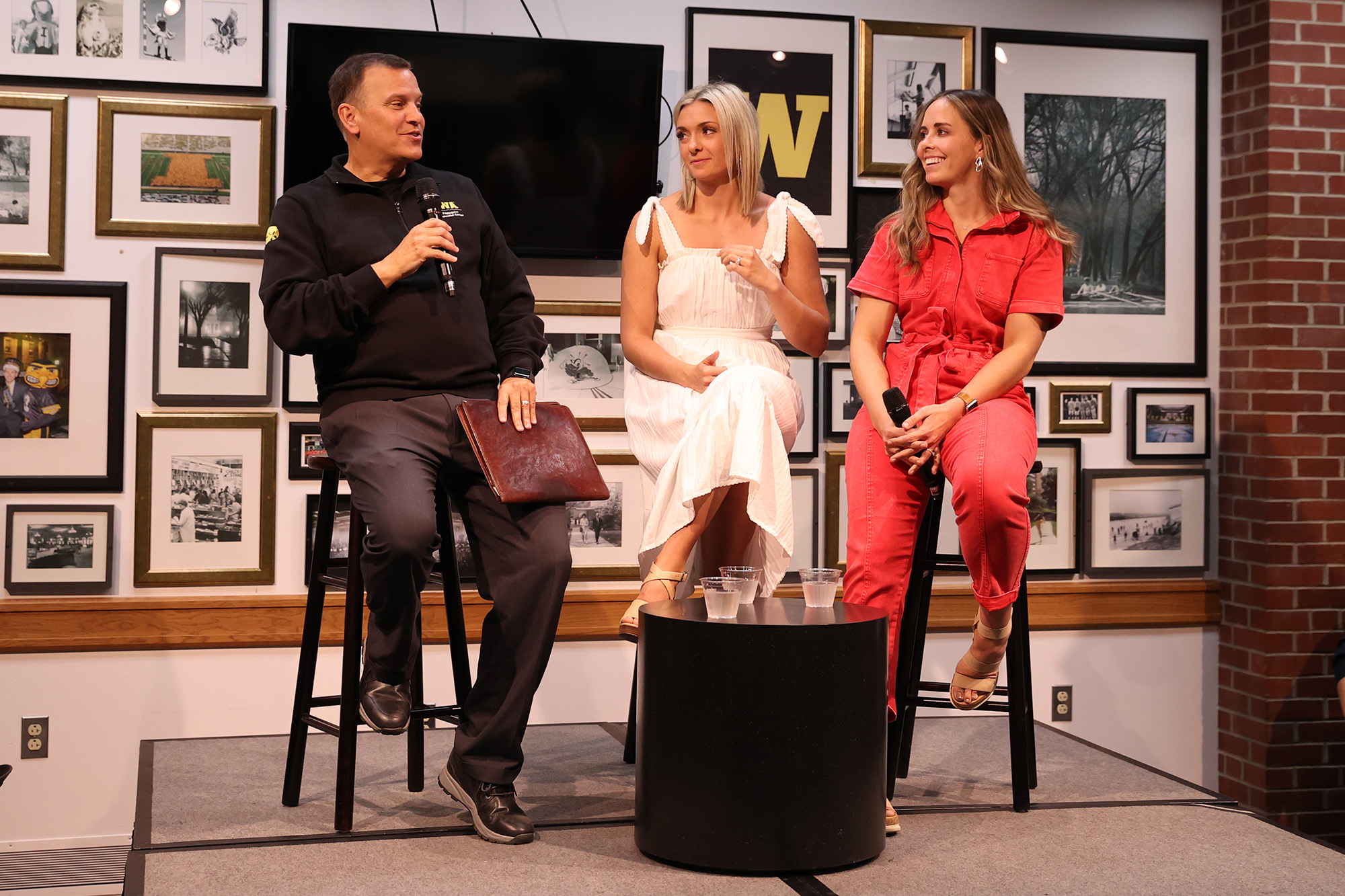 three people on a stage at a speaking event
