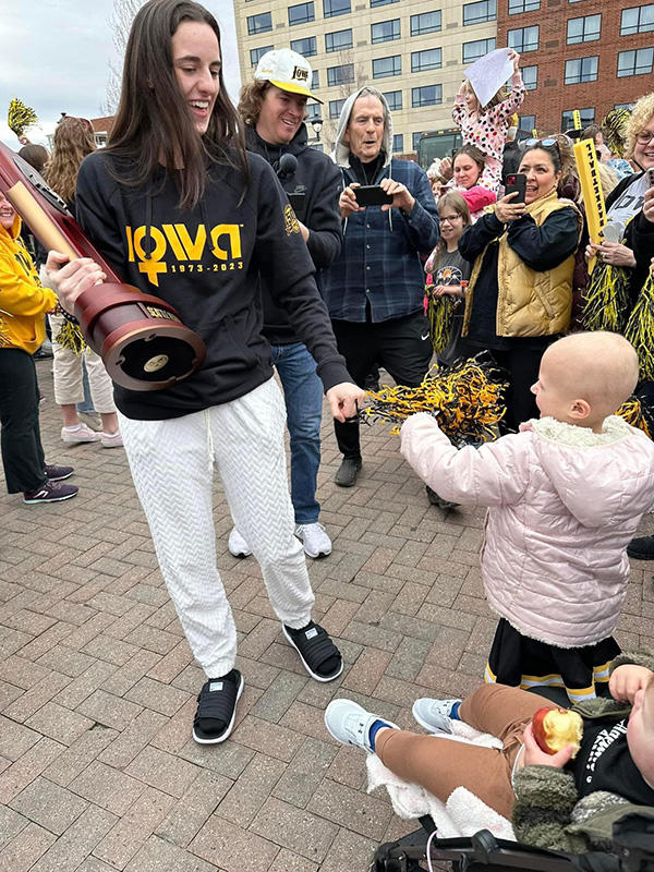 A basketball player giving a child a fist-bump