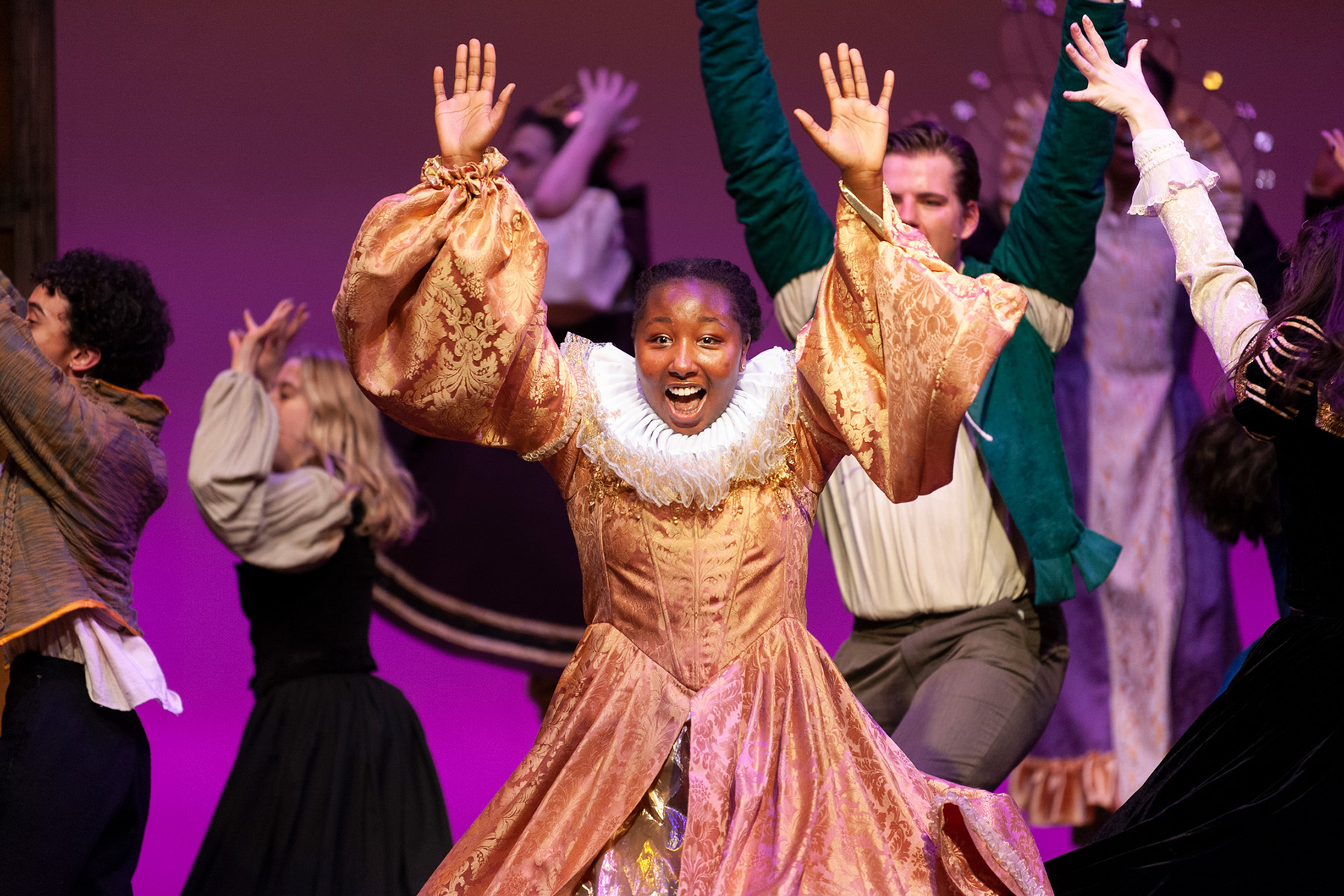 A woman standing on stage in a dress