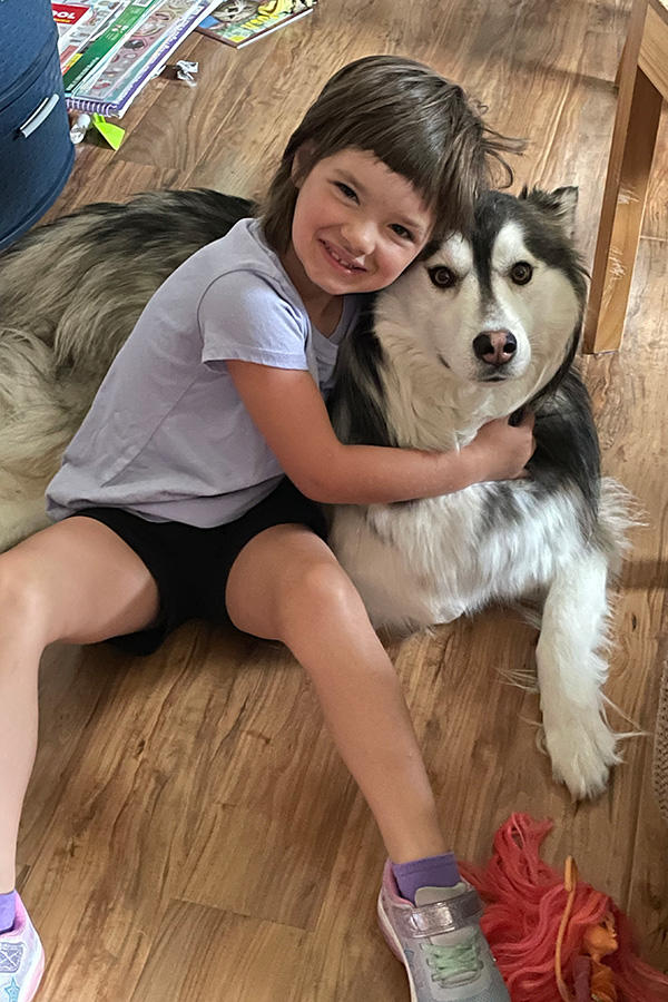 A young girl sitting with a dog
