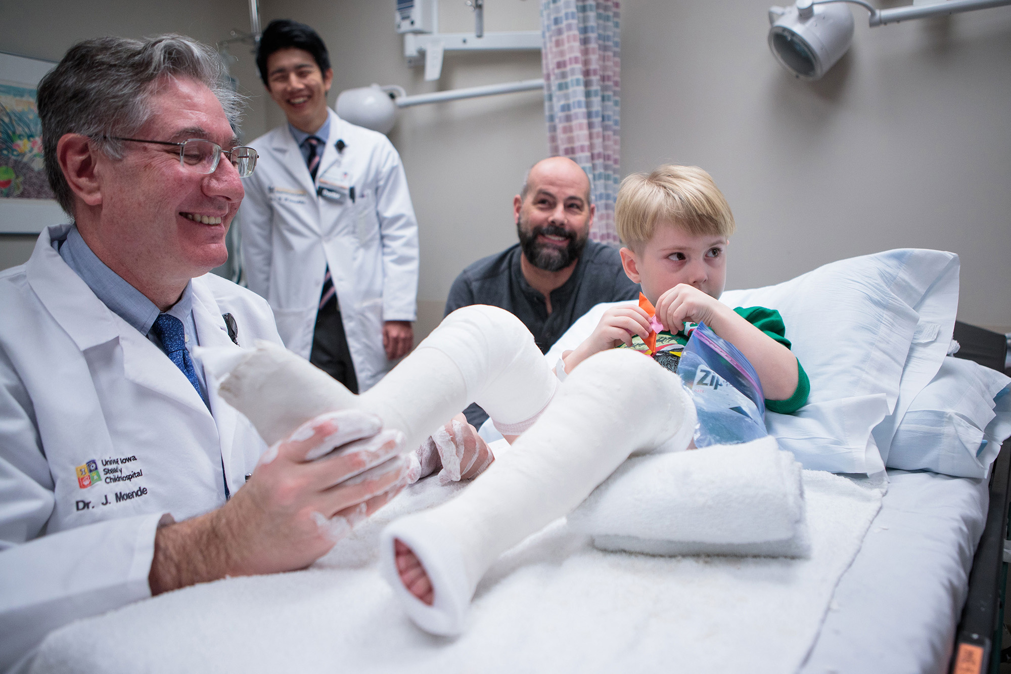 a doctor works with the casts of a young patient with clubfoot