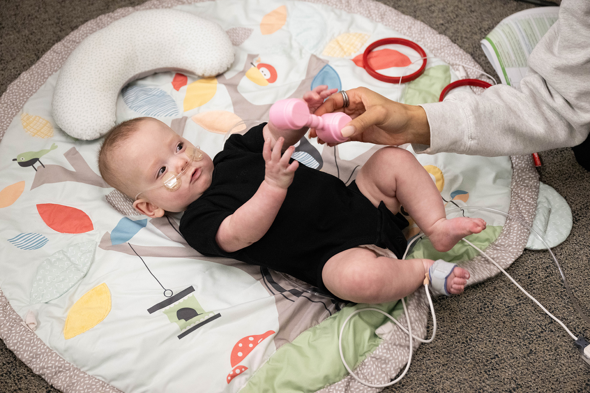 A baby being monitored as it plays with a toy
