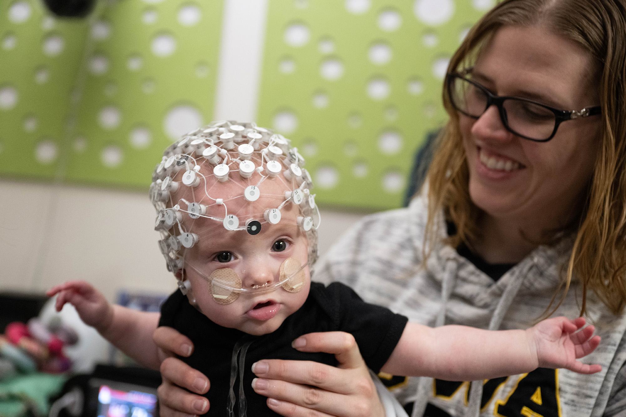 A baby with a set of wires and nodes on his head