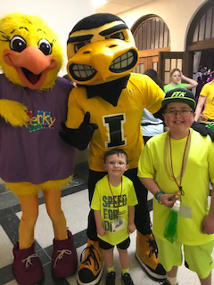 A boy standing with two mascots