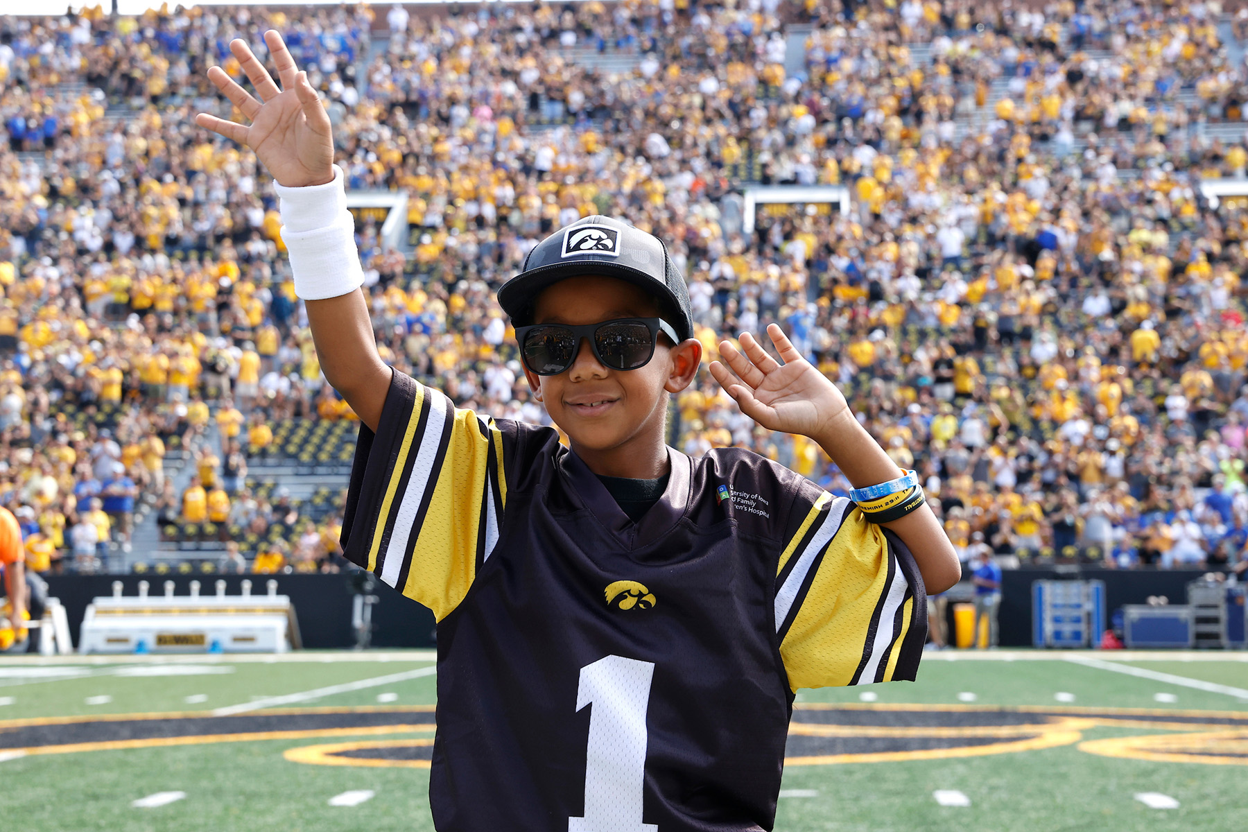A boy holding up his hands in front of a crowd of people