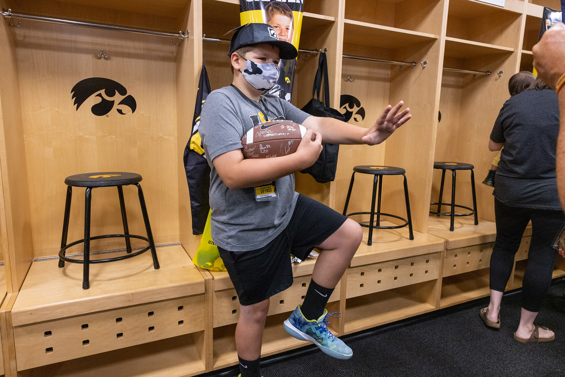 A boy holding a football with many different signatures on it