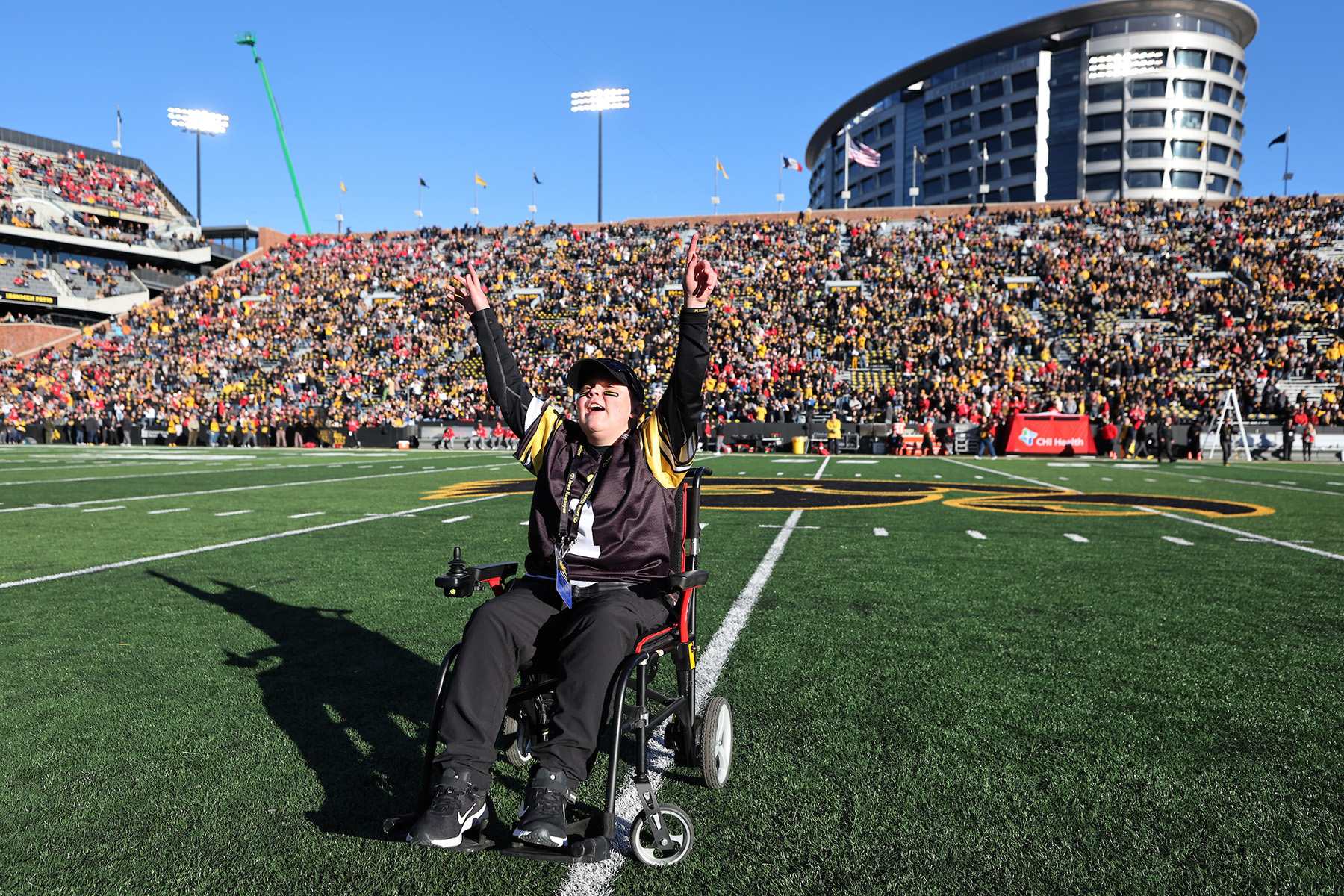 A boy cheering for the crowd on a football field