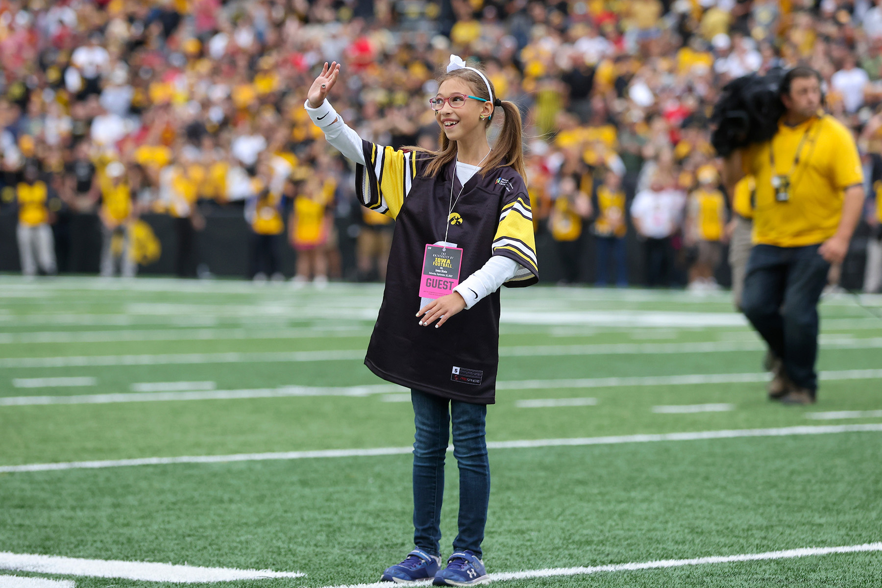 A girl waving to a crowd of fans