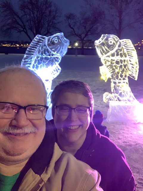 two people posing for a selfie at a light display