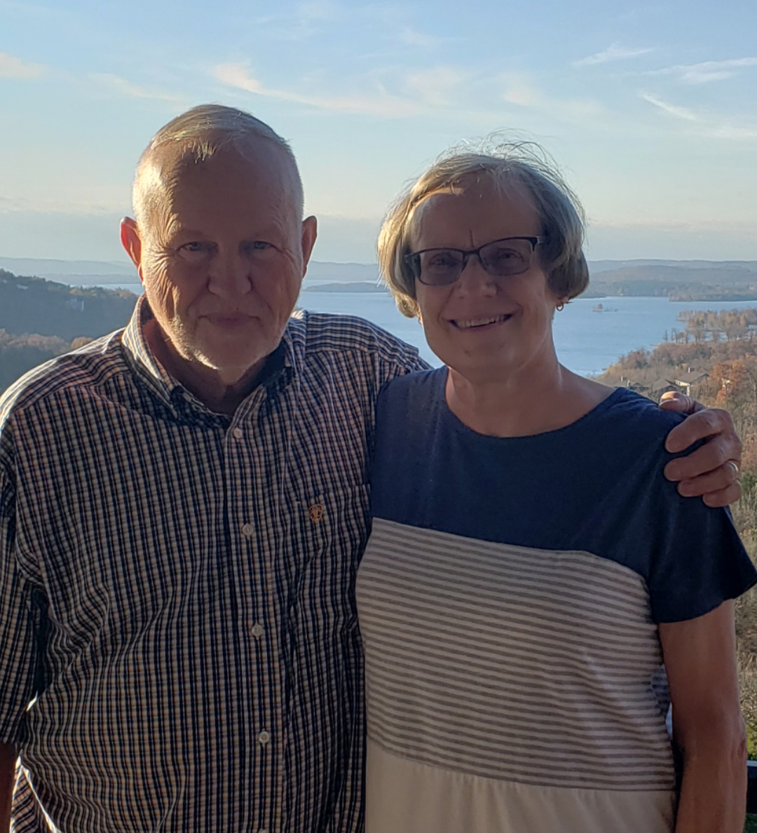 a man and woman posing together outdoors
